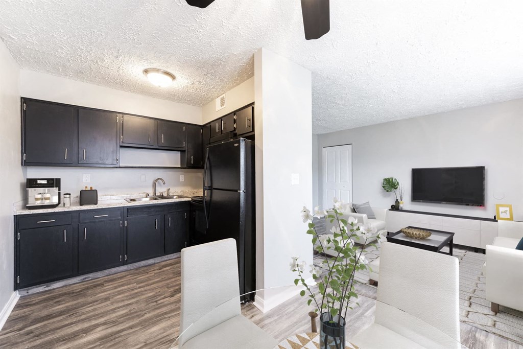 a kitchen and living room with a black refrigerator