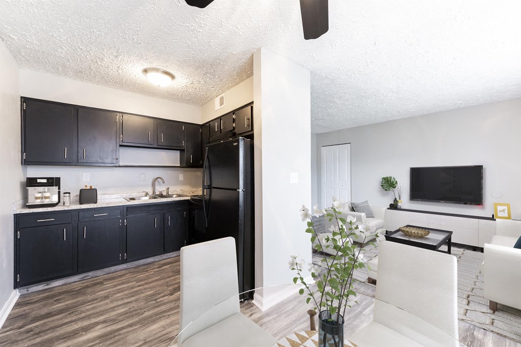 a kitchen and living room with a black refrigerator