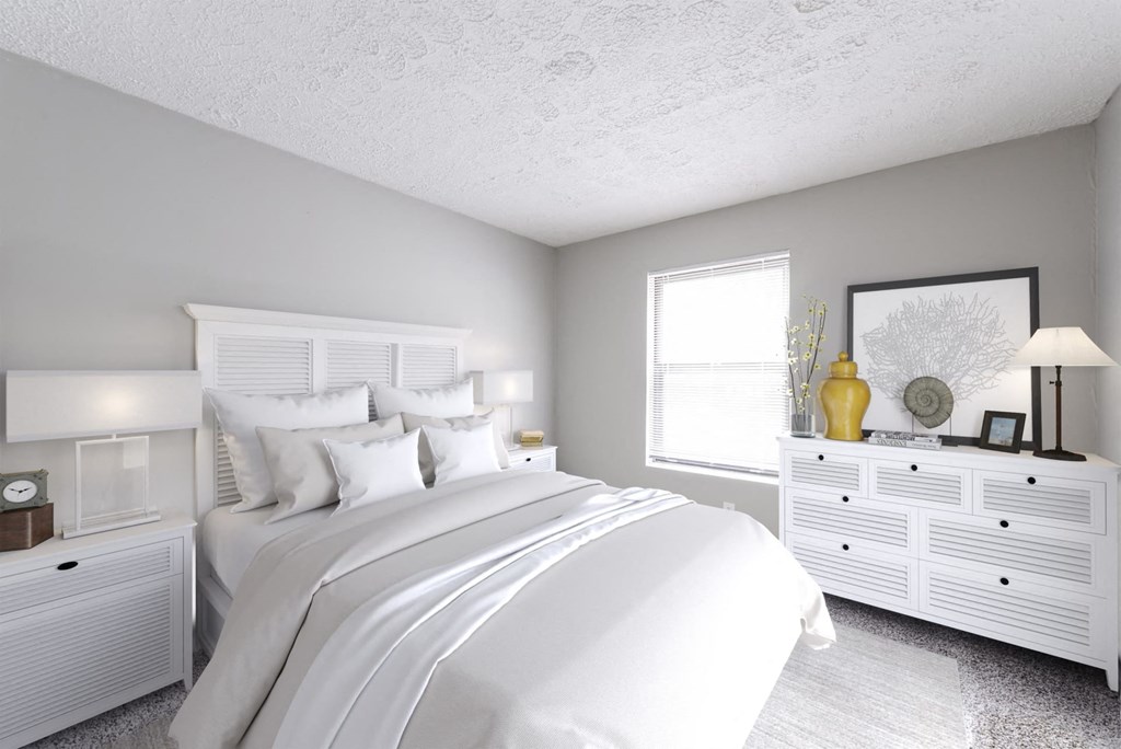 a white bedroom with a large bed and white dressers