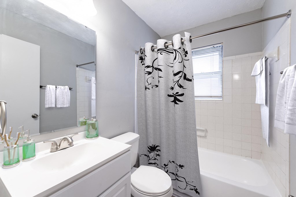 a bathroom with a shower curtain and a sink and a toilet