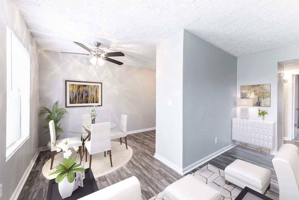a living room and dining room with white furniture and a ceiling fan