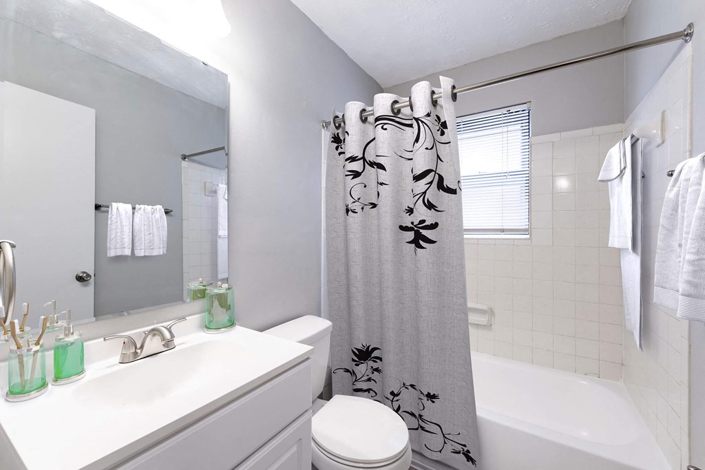 a white bathroom with a shower curtain and a sink