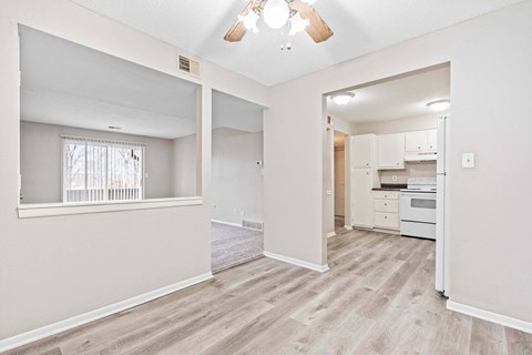 A spacious living room with a kitchen in the background.