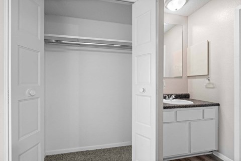 A white bathroom with a sink and mirror.