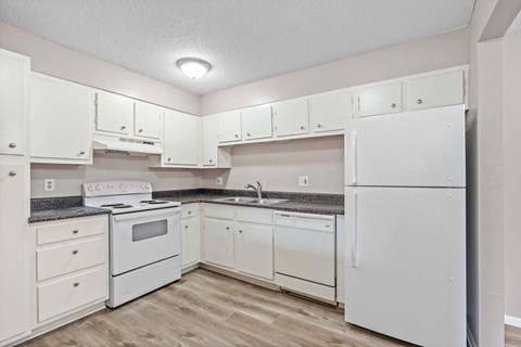 A kitchen with white appliances and cabinets.