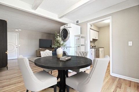 A modern dining room with a round table and white chairs.