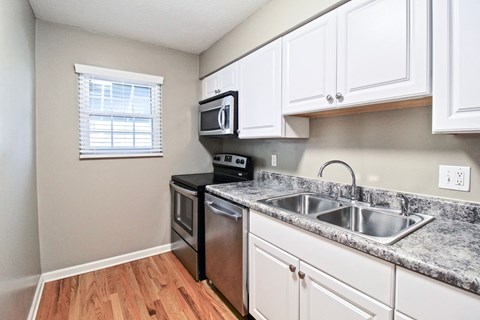 A kitchen with a black stove top oven and white cabinets.