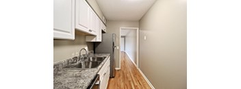 A kitchen with a granite countertop and a refrigerator.