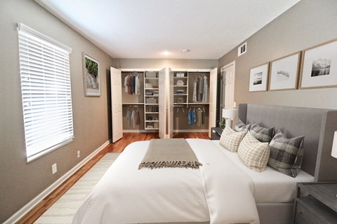 A bedroom with a large bed and a walk-in closet.