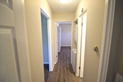 A hallway with a white door on the right and a white door on the left.