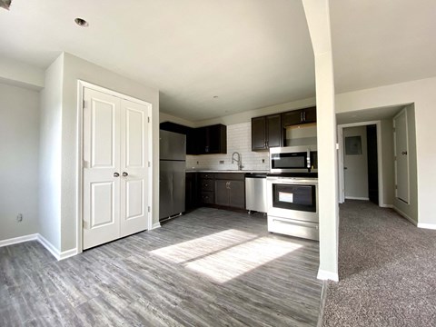 A kitchen with a white door and a microwave above the stove.