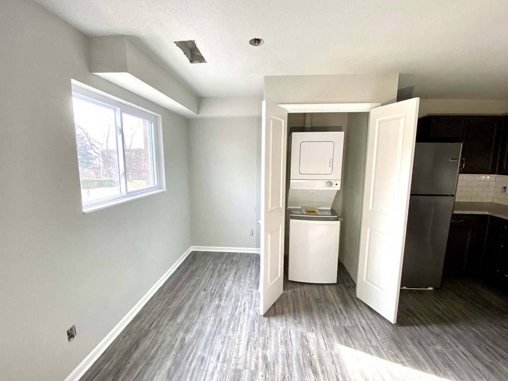 A kitchen area with a refrigerator and a cabinet.
