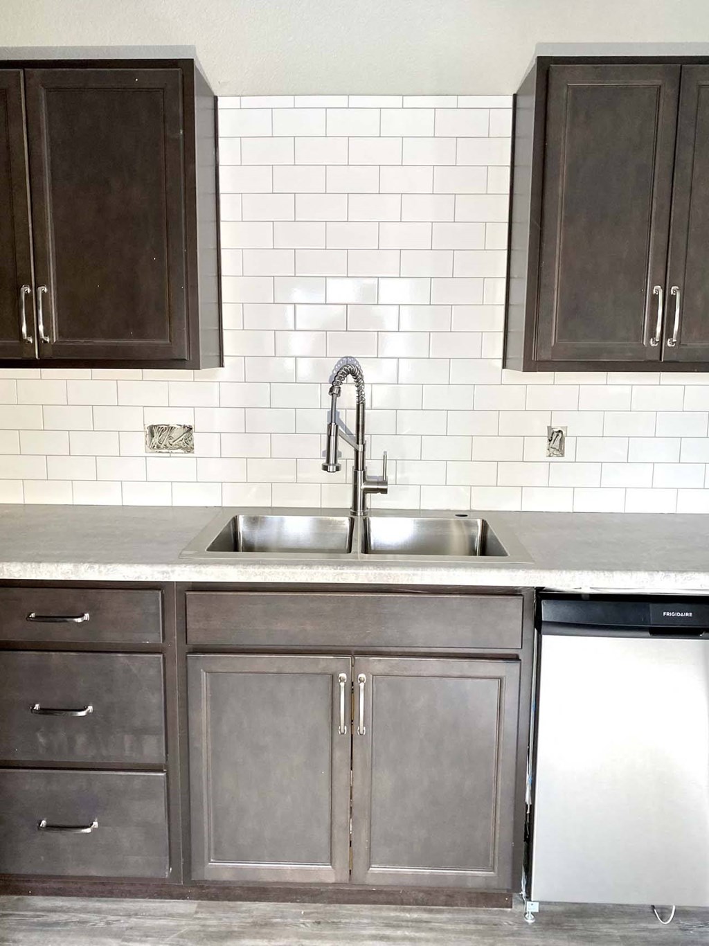 A kitchen with a white sink and a white dishwasher.
