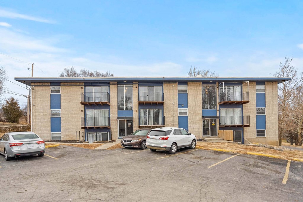 A parking lot with cars and a building in the background.