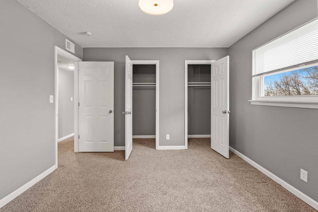 A room with three doors and a window.