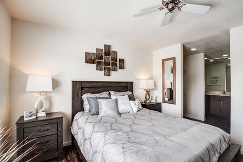 A bedroom with a large bed and a ceiling fan.