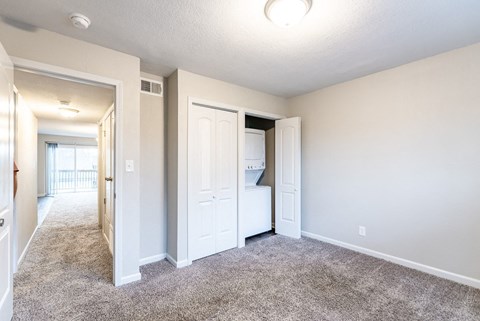 A bedroom with a white door and a window.