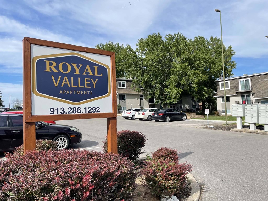 A sign for Royal Valley Apartments with a phone number on it.