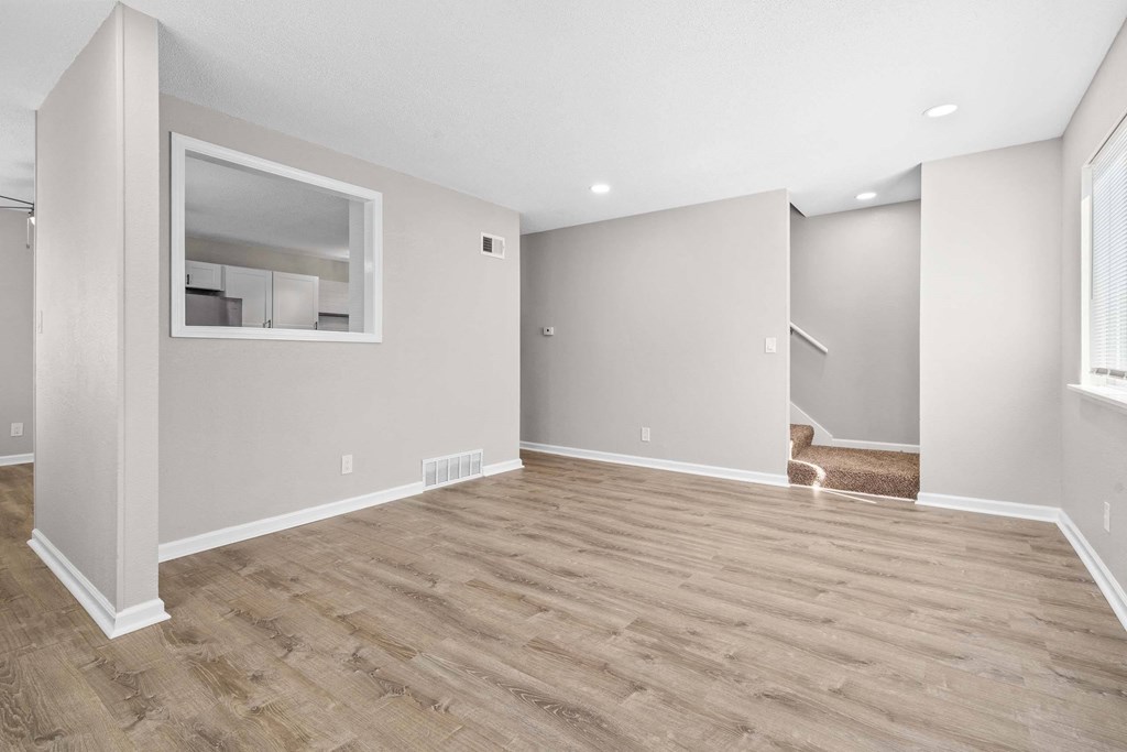 A room with wooden flooring and a large window.