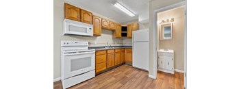 A kitchen with wooden cabinets and white appliances.