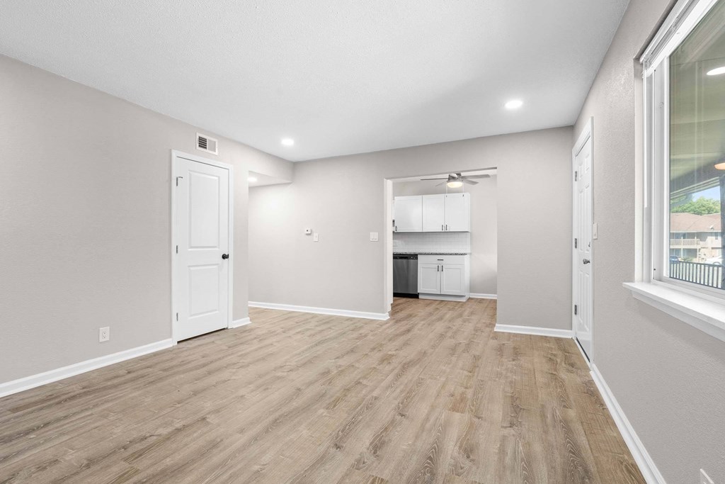 A room with light wood flooring and white walls.