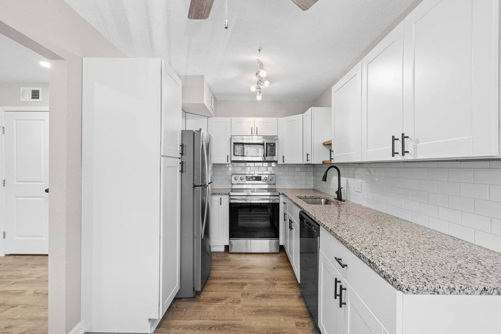 A kitchen with white appliances and cabinets.