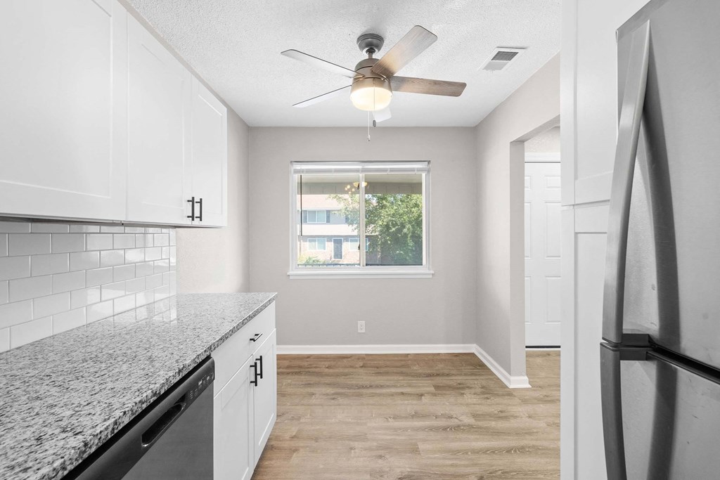 A kitchen with a refrigerator on the right side.