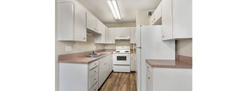 A kitchen with white cabinets and appliances.