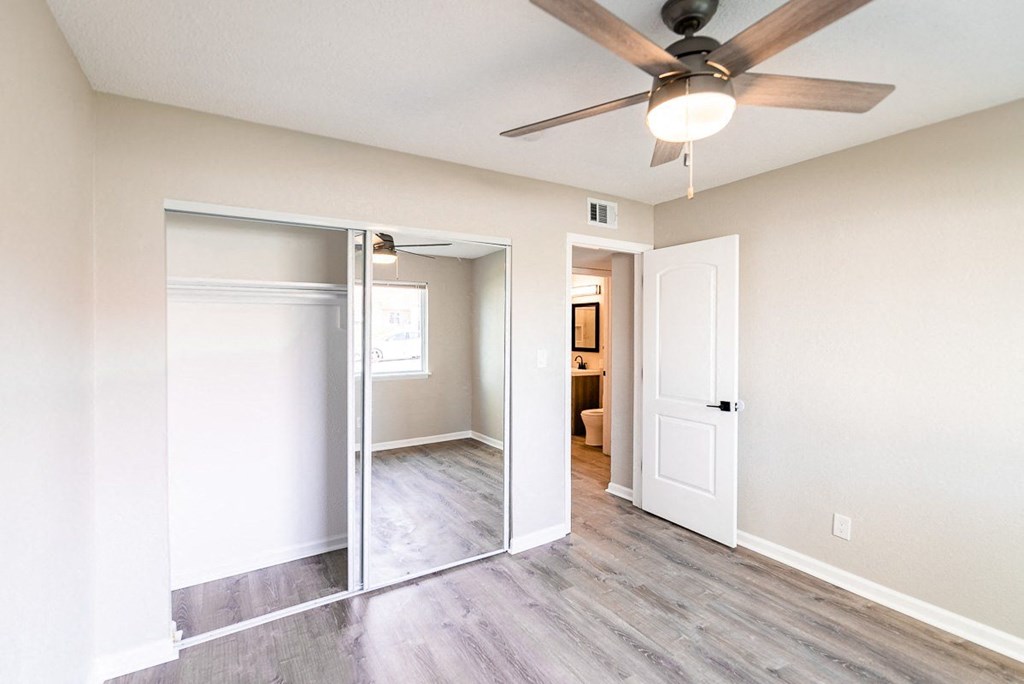A room with a ceiling fan and a sliding door.