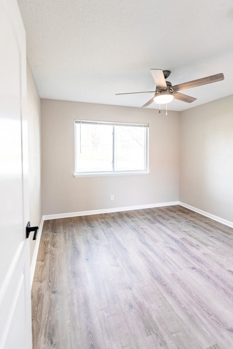 A room with a ceiling fan and a window.