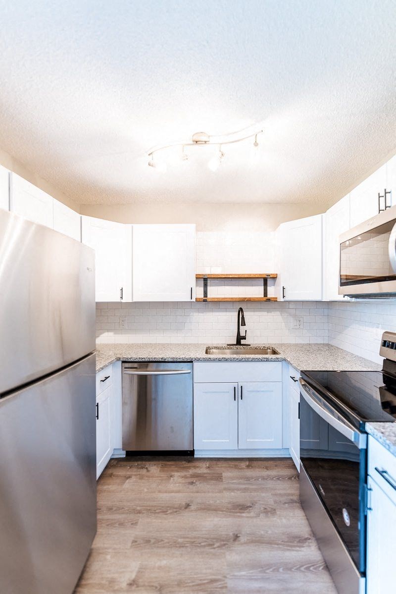 A kitchen with a sink and a refrigerator.