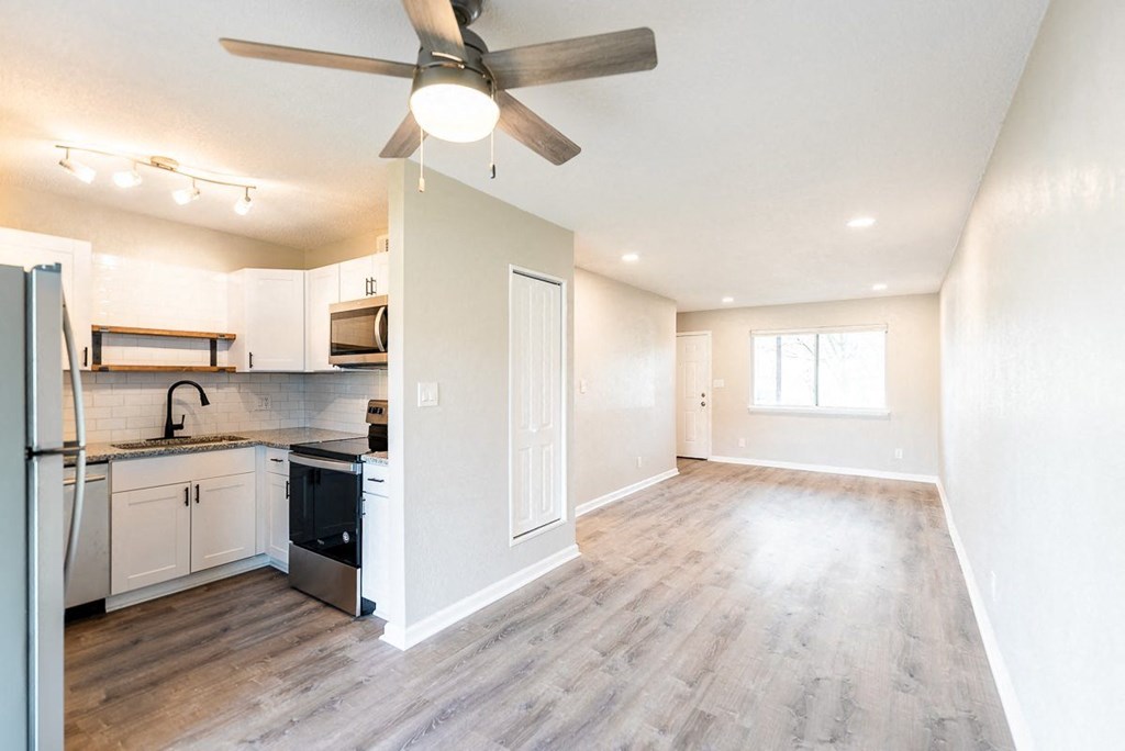 A kitchen with a refrigerator, sink, and stove.
