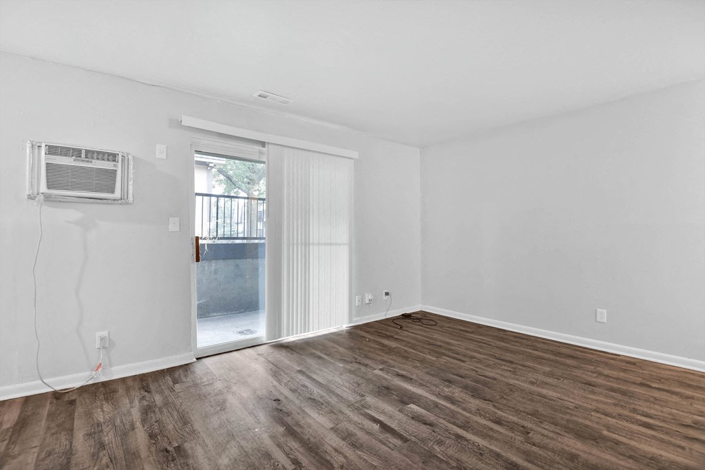 large room with hardwood floors and sliding glass door