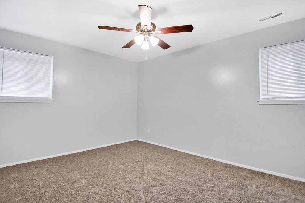 large carpeted room with ceiling fan