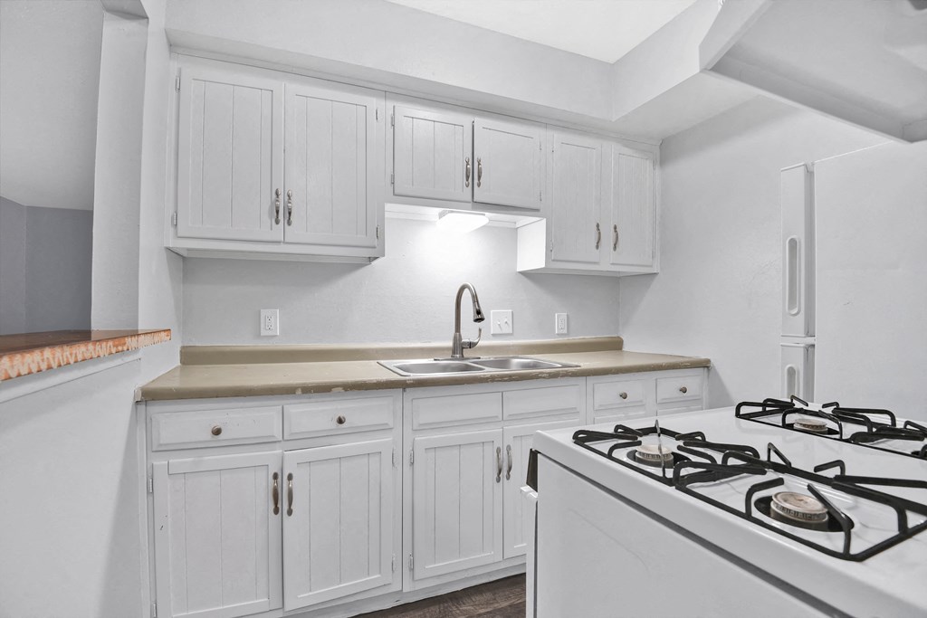 kitchen with oven, cabinets and sink