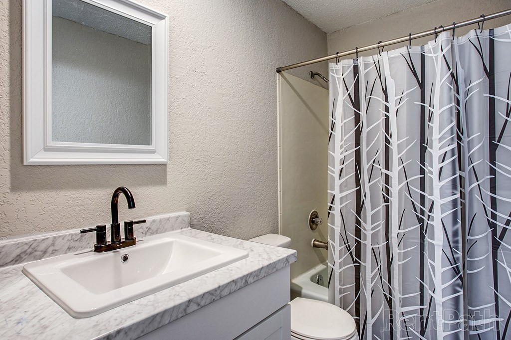 a bathroom with a shower and a sink and a toilet