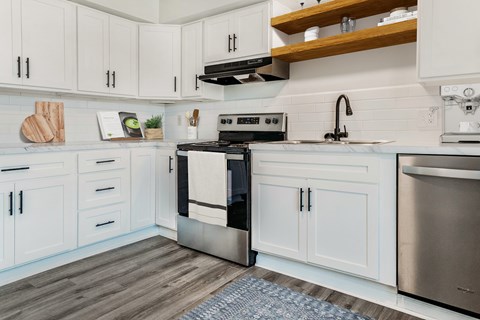 A modern kitchen with white cabinets and a stainless steel oven.