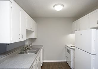 a kitchen with white appliances and a sink and a refrigerator