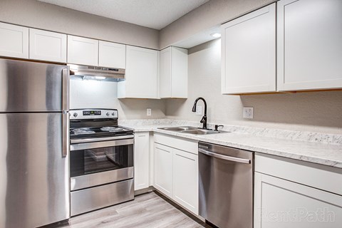 a kitchen with stainless steel appliances and white cabinets