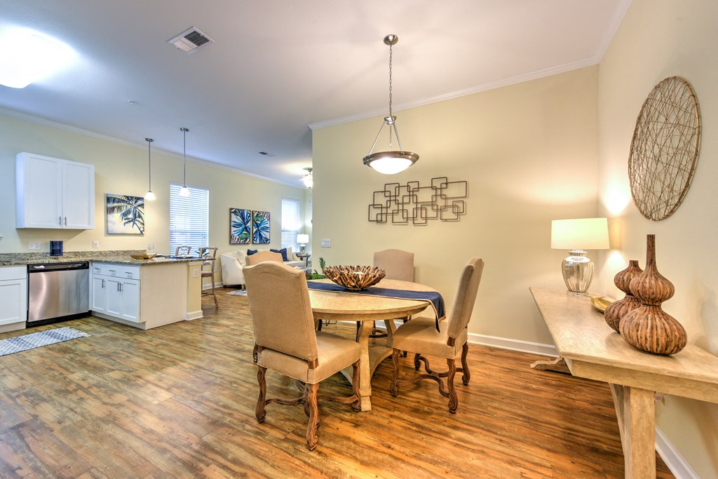 a dining area with a table and chairs and a kitchen in the background at Palm Bay Club, Jacksonville, FL