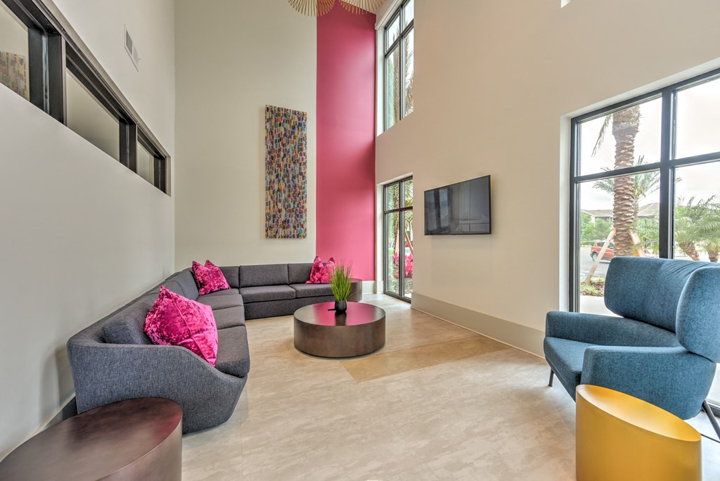 a living room with couches and chairs and a television at Pinnacle Apartments, Jacksonville, 32256