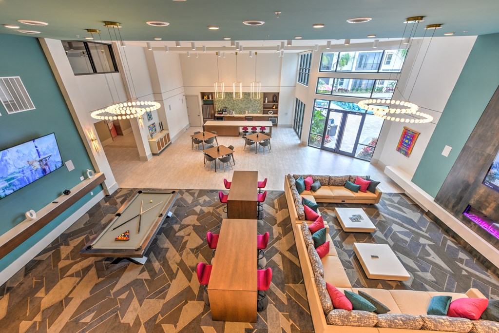 a communal area with couches and tables in a large room with a game room at Pinnacle Apartments, Jacksonville, 32256