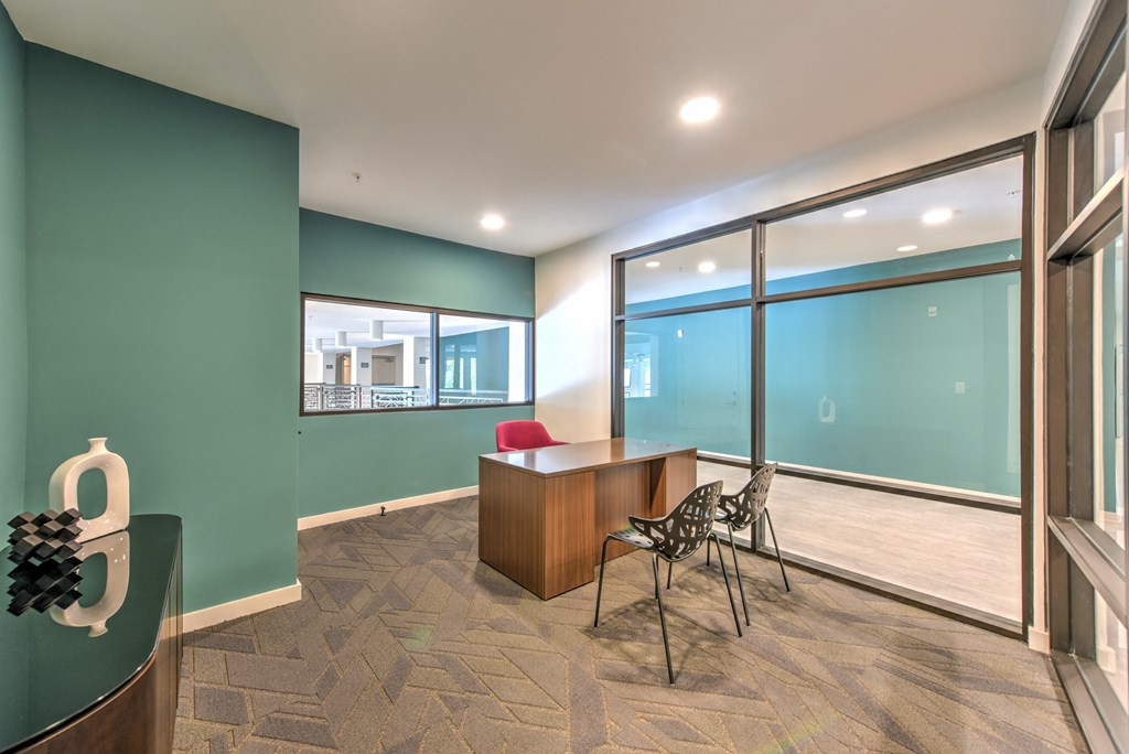 a conference room with large windows and a desk and chairs at Pinnacle Apartments, Jacksonville, 32256
