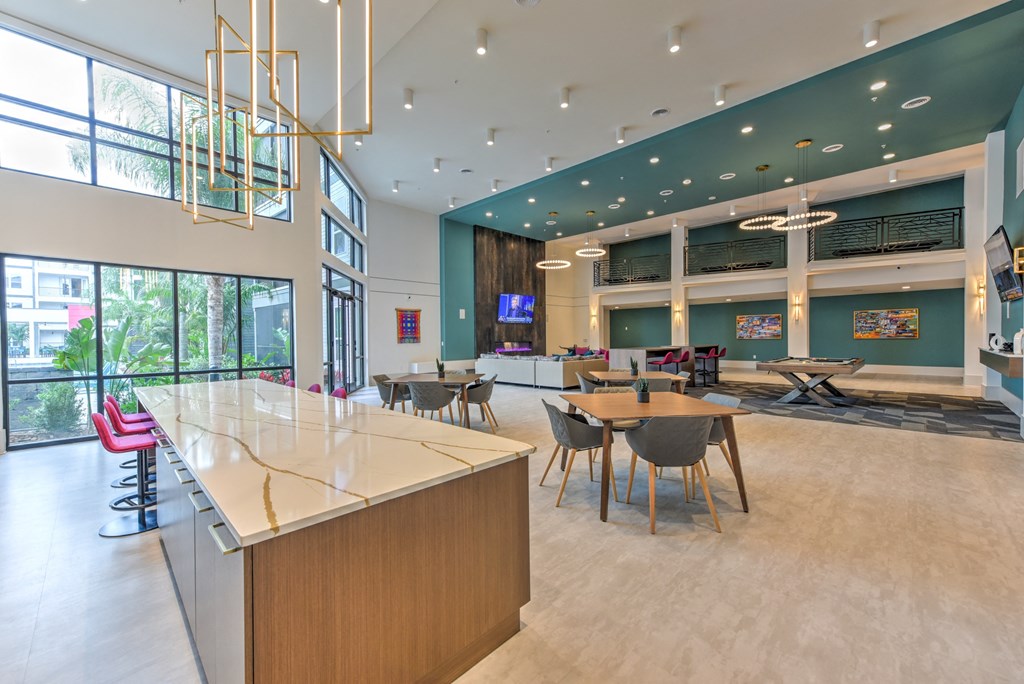 a large lobby with tables and chairs and a reception desk  at Pinnacle Apartments, Jacksonville, 32256