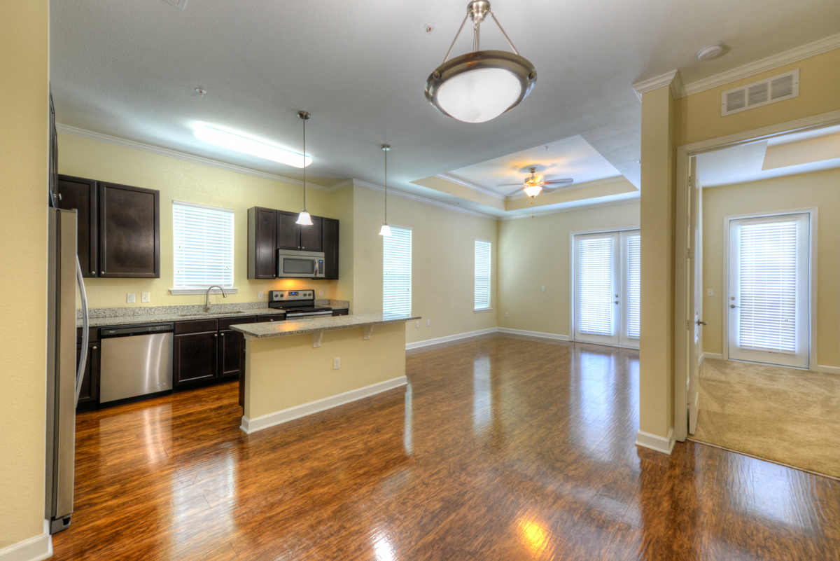 Empty Living Room with a Kitchen in the Background  at Alaqua, Florida