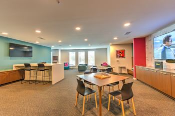 a conference room with a table and chairs and a tv at Pinnacle Apartments, Jacksonville, FL