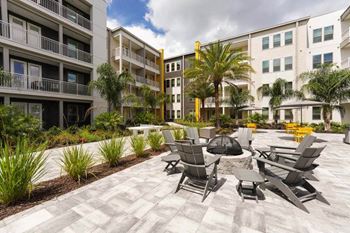 a patio with chairs and a fire pit in front of a building  at Fusion, Jacksonville, Florida