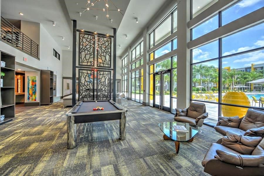 a large room with a pool table and a lot of windows  at Fusion, Jacksonville, FL, 32256