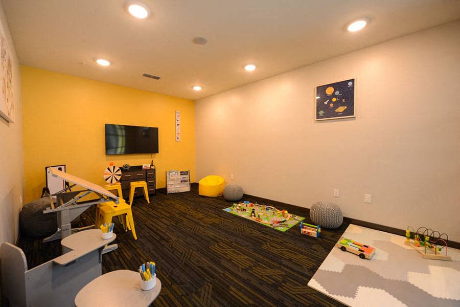 a living room with a childs play area and a television