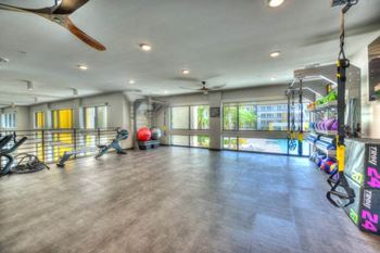 a gym with a large window and a ceiling fan  at Fusion, Jacksonville, FL, 32256